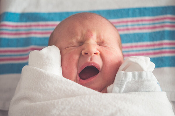 Neugeborenes Kind eingewickelt in einer Decke
