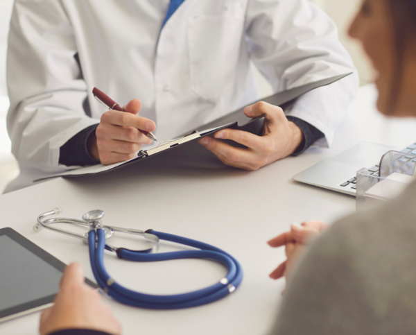 Junges Paar lässt sich von einer Ärztin zu unerfülltem Kinderwunsch beraten