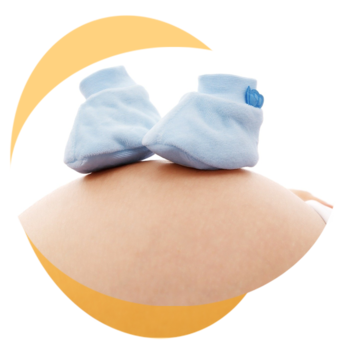 Babyschuhe liegen auf Babybauch 